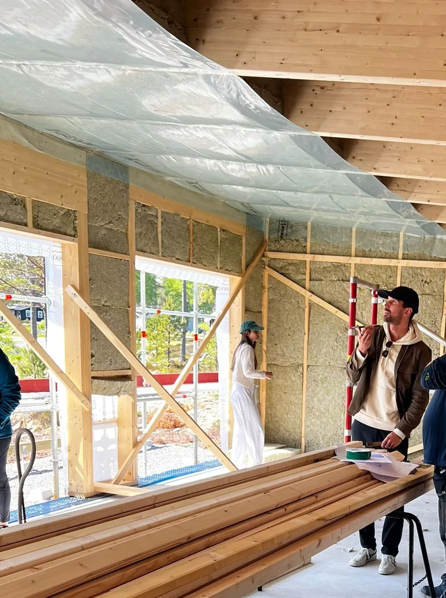 Viktor on the construction site, on a call in the framed house